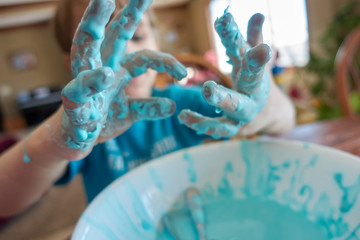 young child with focus on slime covered hands  