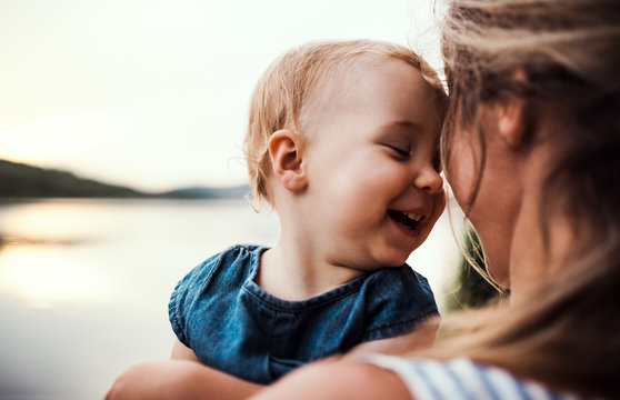 Smiling mother holding toddler outdoors