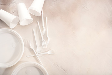Plastic tableware on light background. Environmental protection. Secondary processing. The concept of zero waste.