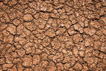 Dry earth, cracked ground, and arid weather.  Dry skin care for parched texture.  Background closeup.