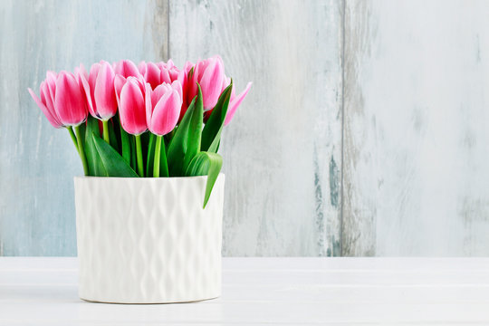 Pink tulips in white ceramic vase
