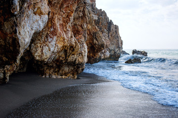 Sandy beach and soft blue ocean wave with white foam.