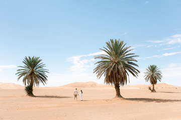 Young couple walking in Sahara desert.