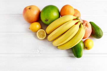 Various fruits on white wooden background.
