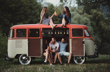 A group of friends at dusk outdoors on a roadtrip through countryside.