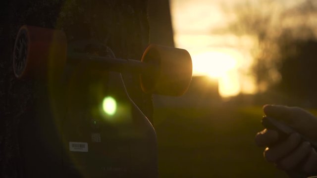 ELECTRIC LONGBOARD, 4K, SUNSET - Electric longboard not working close-up with a controller during sunset