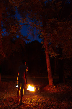 Man and camp fire at night.