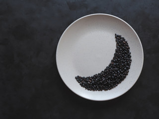 Moon shape laid out coffee beans on a plate. 