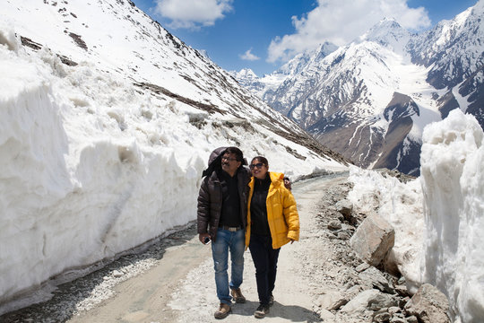 Couple walking through ice walls in Himalaya