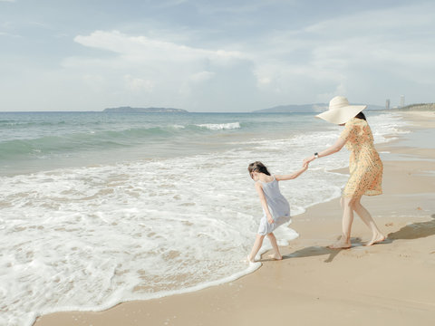 Cute toddler girl and her mother on the seaside