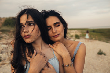 Daughter and mother embracing on beach