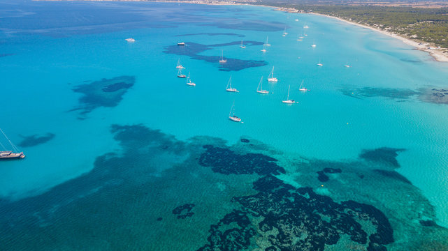 Amazing drone aerial landscape of the charming beach Es Trencs and the boats with a turquoise sea. It has earned the reputation of Caribbean beach of Mallorca. Spain © Matteo Ceruti