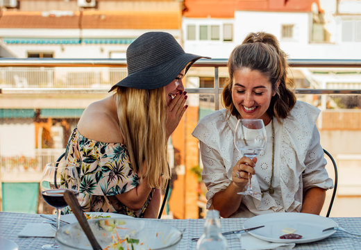 Woman Whispers to Friend