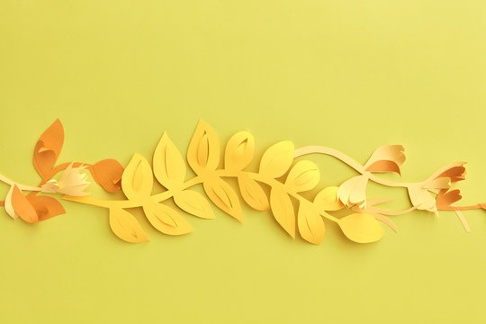 Yellow handmade paper leaves on a yellow background with copy sp - Powered by Adobe