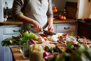 Woman chopping vegetables while cooking