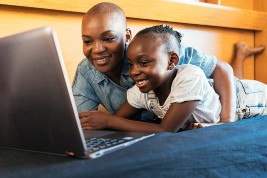 Beautiful woman with her cute daughter using laptop
