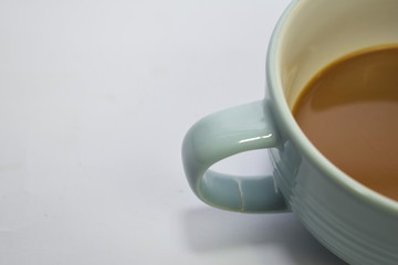 Close up hot cappuccino coffee in a blue cup isolated on a white background