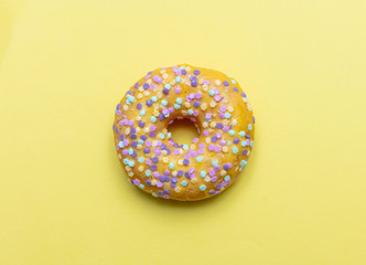 Doughnut with star shape sprinkles isolated on yellow color background