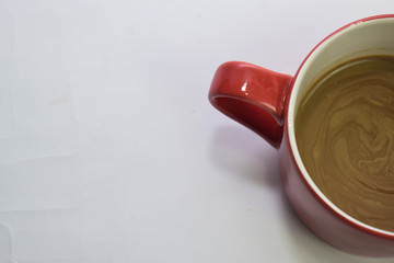 Close up hot cappuccino coffee in a red cup isolated on a white background