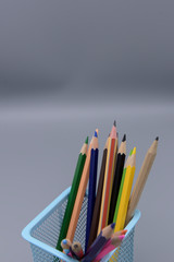 Fototapeta premium School supplies, glasses, crayons in pencil boxes on gray backgrounds.