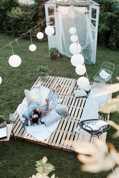 Group Of Friends Watching Open Cinema In Garden