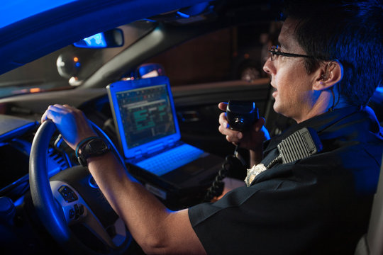 Police Officer Inside Car Talking On Radio