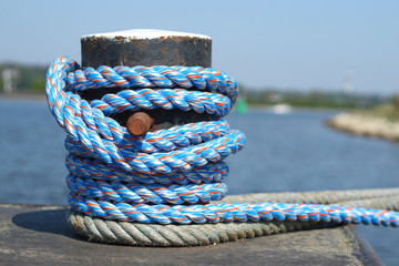 Blue mooring rope around a bollard at a quay