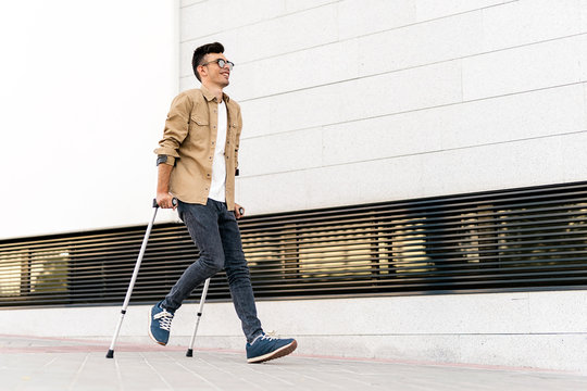 Portrait of happy young man using crutches
