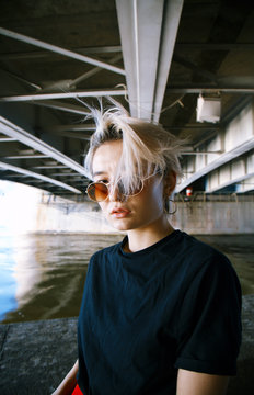 Portrait of a girl under a bridge near the water