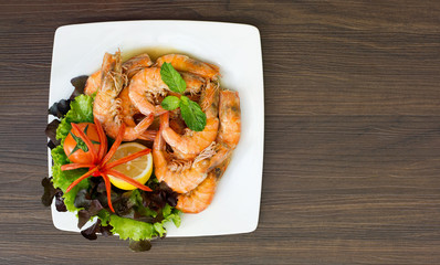Baked Shrimp with salt and vegetables on white dish and dark brown background