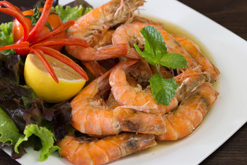 Baked Shrimp with salt and vegetables on white dish and dark brown background
