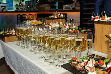 A large number of glasses with champagne stands on a table