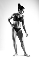 muscular athletic woman in a swimsuit. photography black and white in the studio