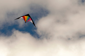 Fototapeta na wymiar A bright kite flying against the backdrop of thunder clouds.