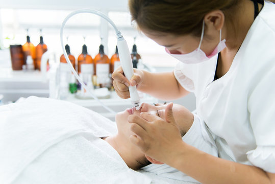 Woman receiving facial treatment in spa