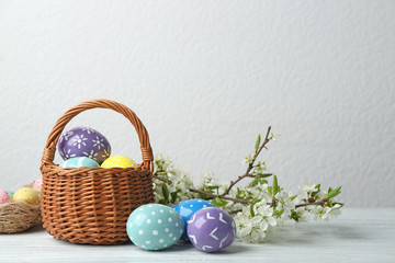 Composition with painted Easter eggs and blossoming branches on table. Space for text