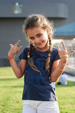 Georgeous kid portrait smiling at camera with rocking hands.
