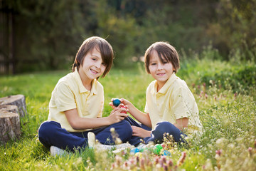 Sweet children, boy brothers with bunny ears, egg hunting for Easter, child and Easter day traditions