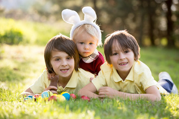 Sweet children, boy brothers with bunny ears, egg hunting for Easter, child and Easter day traditions