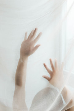 Artistic series of hands moving behind silk