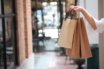 Young woman holding sale shopping bags. consumerism lifestyle concept in the shopping mall