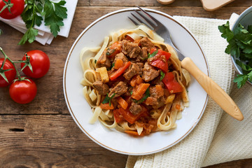 Lagman noodles with beef meat and vegetables in a white bowl