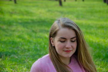 Naklejka premium Portrait of a beautiful girl in bright pink clothes on a warm afternoon in the park