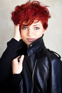 Portrait of a beautiful young red-haired woman with short hair looking at camera.