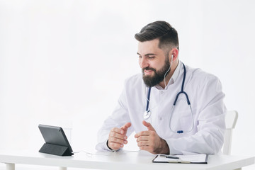 Sincere doctor is looking at camera of pc tablet and giving positive encouragement