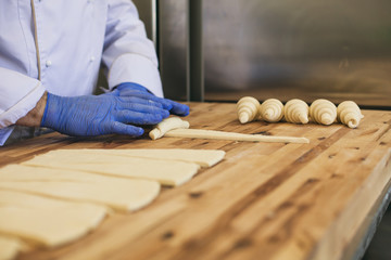A hand of a chef roll french bread croissant 