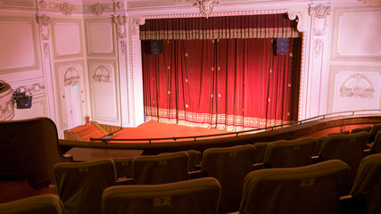 view from within a theater with stage chairs and curtain