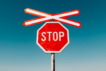 Crossbuck and stop sign on countryside road and railway intersection