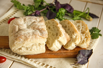 White wheat bread, Italian ciabatta, cut into pieces on a wooden board.Slices of white bread for sandwiches