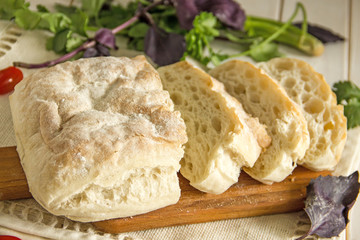 White wheat bread, Italian ciabatta, cut into pieces on a wooden board.Slices of white bread for sandwiches